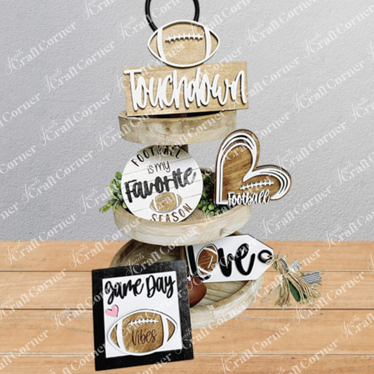 Three-tiered wooden decorative tower with football-themed signs on a wooden surface.