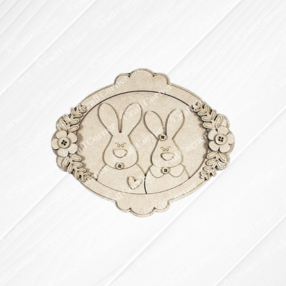 Bring charm to your space with Janet's Craft Corner Easter Decor Set – a DIY kit featuring an ornate oval wooden plaque with two smiling cartoon bunnies, perfect for handmade seasonal decor. Choose from 5 designs!.