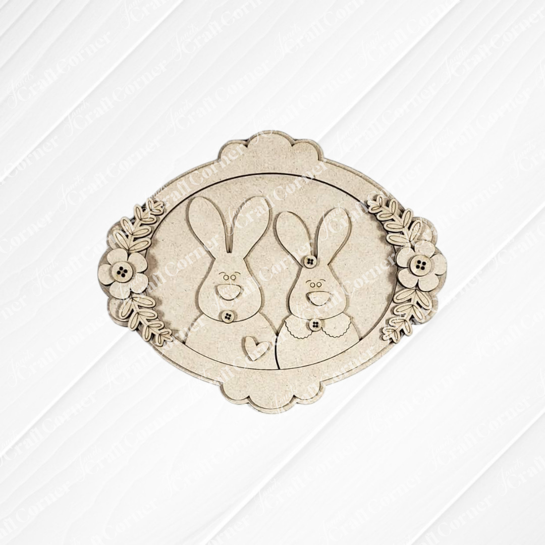 Janet's Craft Corner Framed Bunny Couple Door/Wall Hanger DIY kit includes a laser-cut plaque with button, bow tie, and heart details in a floral oval frame—ideal for seasonal home decor or as a charming craft project. Set of 1.