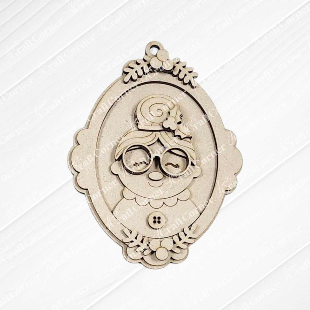 The Mrs. Claus Ornaments by Janet's Craft Corner feature an intricately engraved cartoon grandmother with glasses, bun, and flowers in a light wood finish—ideal for holiday decorations or DIY craft kits.