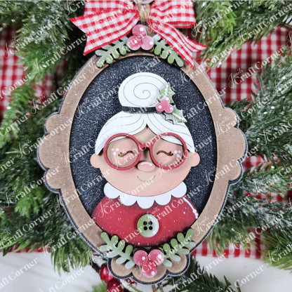 Add charm to your Santa Ornaments collection with Janet's Craft Corner Mrs. Claus Ornaments—a vintage frame-shaped festive ornament featuring a smiling grandmother with white hair, red glasses, and a gingham bow for your tree.