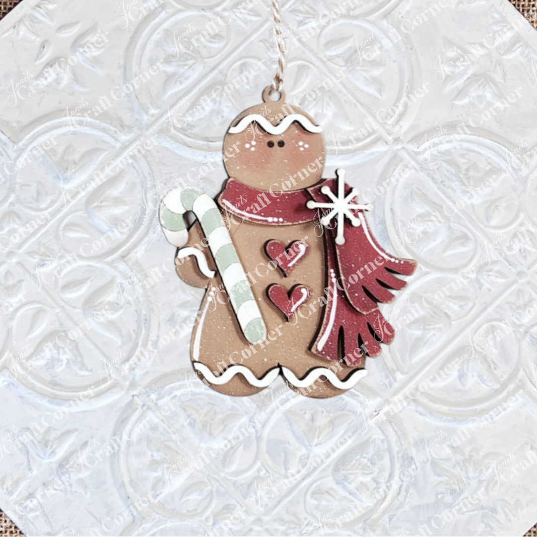 The Gingerbread Ornaments - DIY holiday craft kit by Janet's Craft Corner features 8 cookie ornaments with white icing, red scarves, heart shapes, candy canes, and snowflakes—perfect for festive décor.