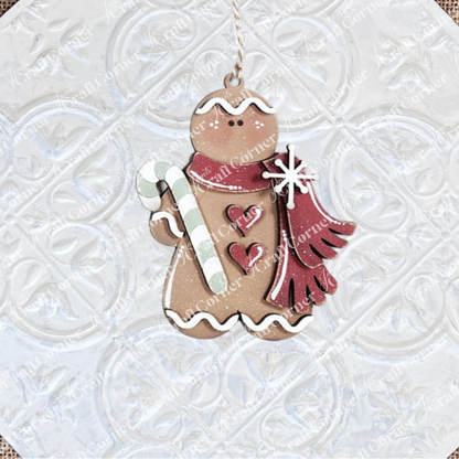 The Gingerbread Ornaments - DIY holiday craft kit by Janet's Craft Corner features 8 cookie ornaments with white icing, red scarves, heart shapes, candy canes, and snowflakes—perfect for festive décor.