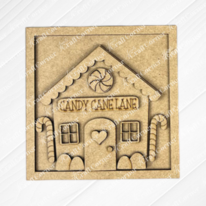 The Gingerbread Squares plaque by Janet's Craft Corner is perfect for tiered trays, featuring a gingerbread house with "Candy Cane Lane" above the door, candy cane accents, a heart on the door, and a peppermint candy above the roof.