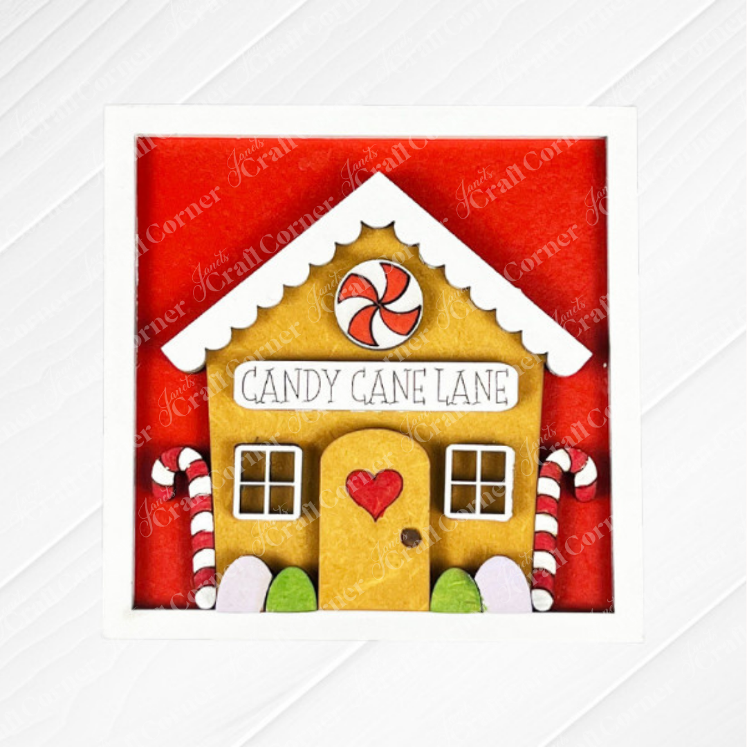 A square illustration from Janet's Craft Corner’s Gingerbread Squares features a gingerbread house with candy canes, heart door, “Candy Cane Lane” sign, red background, and white border—ideal for DIY holiday decor or Swappable Square Displays.