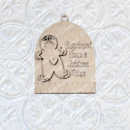 The Gingerbread Ornaments DIY holiday craft kit by Janet's Craft Corner includes 8 wooden ornaments featuring smiling gingerbread figures and “Gingerbread Kisses & Christmas Wishes” text—perfect for charming holiday décor.