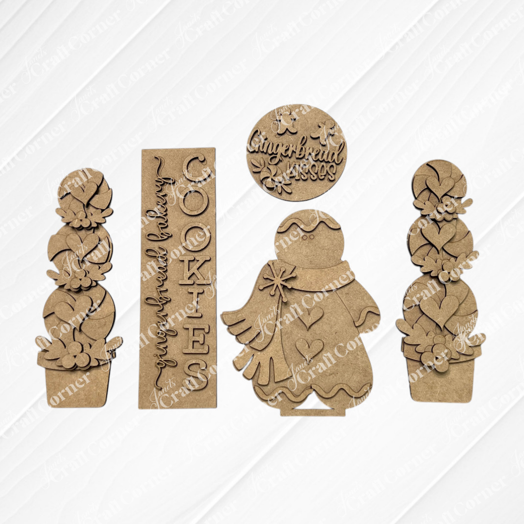 Janet’s Craft Corner Gingerbread Interchangeable Porch Set includes five laser-cut wood shapes: two topiary pots with hearts, a “Cookies” sign, a gingerbread figure, and a “Gingerbread Kisses” round—perfect for DIY farmhouse porch decor.
