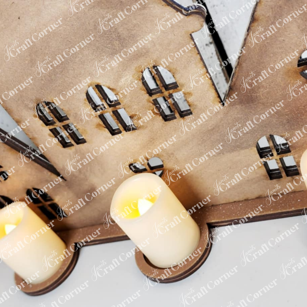 Janet's Craft Corner Gingerbread Village Votive Holder Shelf Sitter features a wooden house with black and white windows, plus two battery LED candles for a cozy glow—an ideal choice for festive home decor.