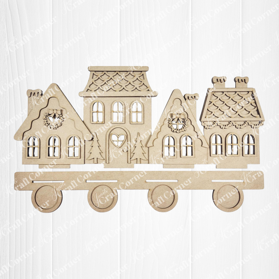 The Gingerbread Village Votive Holder Shelf Sitter by Janet's Craft Corner features four festive, connected houses on wheels—ideal as seasonal home decor. Display this charming accent on a white wooden surface for a cozy holiday touch.