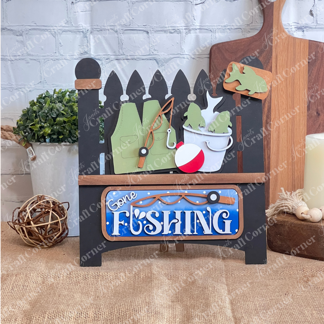 Janet's Craft Corner Gone Fishing Interchangeable Insert is a DIY seasonal home decor craft kit featuring 3 fishing-themed pieces, perfect for adding rustic charm to your space.