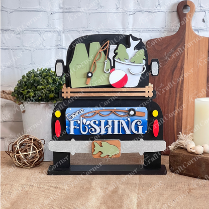 The Gone Fishing Interchangeable Insert by Janet's Craft Corner features a truck with fishing gear, fish bucket, and bobber—perfect for your DIY seasonal home decor craft kit (1 set of 3 pieces) as a charming decorative accent.