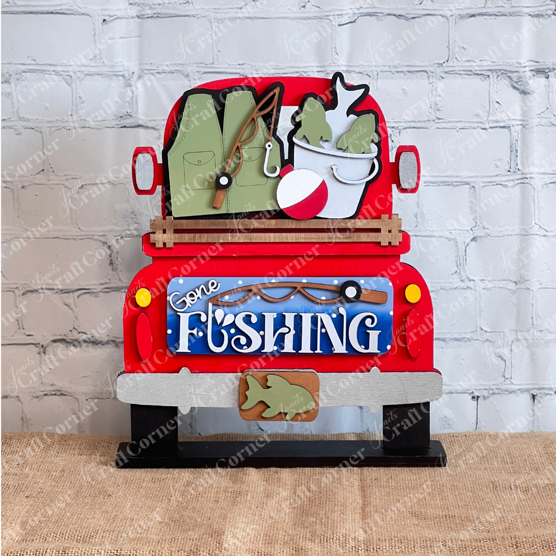 Janet's Craft Corner Gone Fishing Interchangeable Insert is a DIY craft kit (1 set of 3 pieces) featuring a red truck with fishing gear and a “Gone Fishing” tailgate sign—perfect for seasonal home decor.