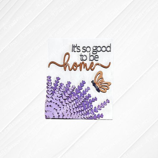 Janet's Craft Corner Lavender Switchable Farmhouse Sign—DIY kit with "It's so good to be home" (home in cursive), butterfly, and lavender on white. Perfect small-space decor or tiered tray accent. Set of 1.