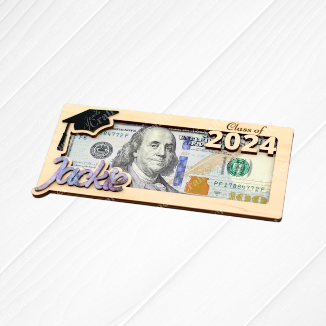 The Graduation Money Holder by Janet's Craft Corner showcases a $100 bill with “Class of 2024,” a graduation cap, and “Jackie” in script on a gold-bordered frame—an ideal personalized gift for graduates.