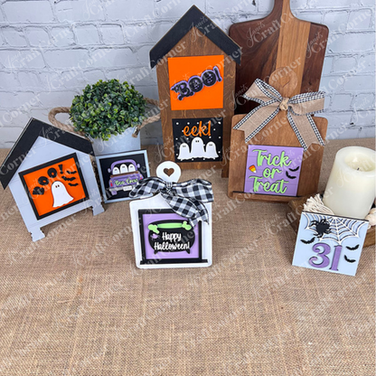 Janet's Craft Corner's Oct 31 Squares tiered tray decor displays wood cut-outs and Swappable Squares with "Boo!" and "Trick or Treat," plus ghost, bat, and spider designs on a burlap table with a plant.