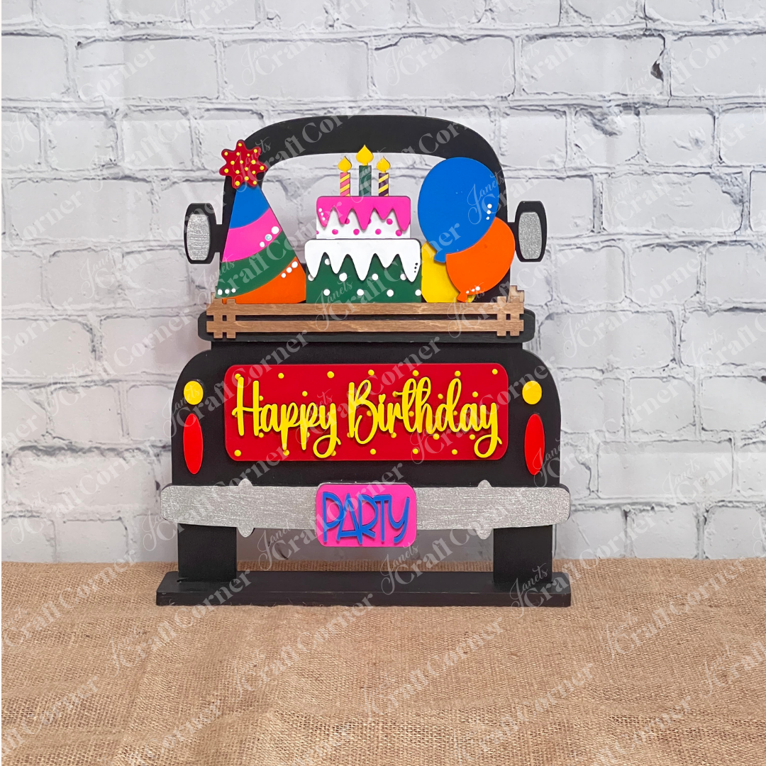 Introducing the Birthday Interchangeable Insert from Janet's Craft Corner—an eye-catching festive decoration shaped like a car. It features a "Happy Birthday" sign, vibrant balloons, and a tiered cake on top, with the tailgate adorned with bright "PARTY" letters on a black antique truck. This part of a versatile DIY home decor kit is ideal for enhancing any craft project.