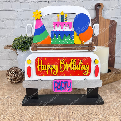 Introducing the Birthday Interchangeable Insert from Janet's Craft Corner—an eye-catching festive decoration shaped like a car. It features a "Happy Birthday" sign, vibrant balloons, and a tiered cake on top, with the tailgate adorned with bright "PARTY" letters. This part of a versatile DIY home decor kit is ideal for enhancing any craft project.