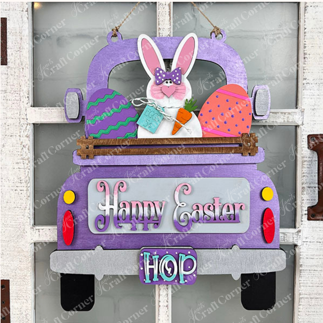 Janet's Craft Corner offers an Antique Truck Base with Insert, a DIY home decor kit featuring an antique truck labeled "Happy Easter" and "HOP," carrying colorful eggs and a bunny with a carrot against a white brick wall on burlap, perfect for charming seasonal decor.