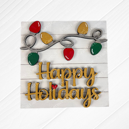 Janet's Craft Corner Christmas Icon Swappable Squares DIY kit features a wooden sign with "Happy Holidays" in gold script and festive lights on a white plank background—ideal for your seasonal home decor.