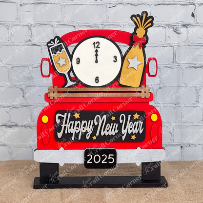 Janet's Craft Corner presents the New Year Interchangeable Insert, a DIY home decor kit with 3 pieces: a decorative red truck adorned with "Happy New Year," clock, champagne glass, and party popper. Perfect against a brick wall with plants and candles for festive charm.
