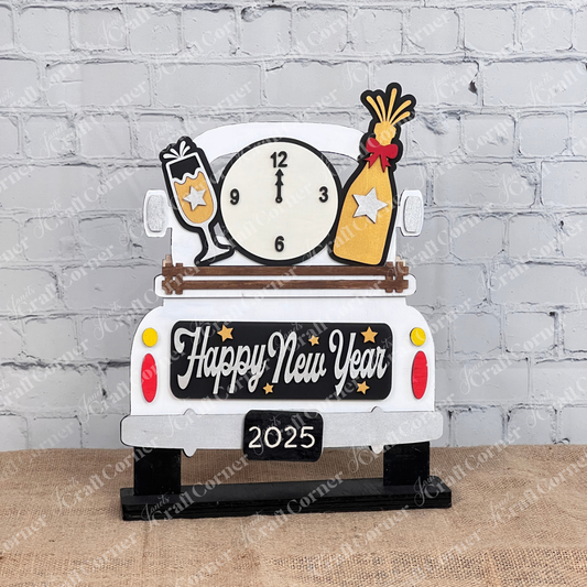The New Year Interchangeable Insert from Janet's Craft Corner is a DIY home decor kit featuring a white truck with "Happy New Year," a midnight clock, champagne set, and burlap. Ideal for enthusiasts, it includes a plant and candle against a brick wall.
