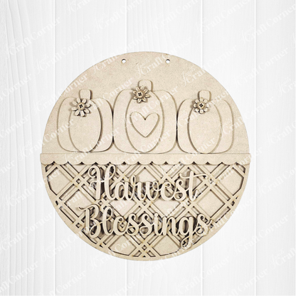 Janet's Craft Corner Harvest Blessings Wall Hanger DIY kit features three pumpkins with floral and heart accents above a lattice, plus “Harvest Blessings” cut out—perfect for creating your own fall home decor. Set of 1.