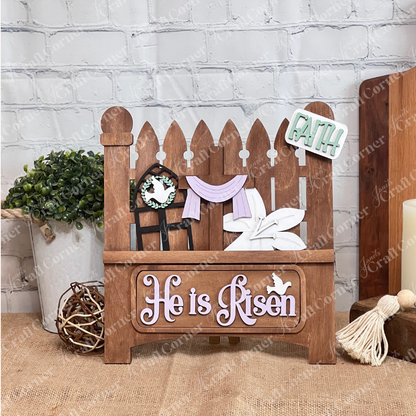 Add charm to your craft kit with Janet's Craft Corner DIY decor: a white picket fence featuring a rabbit with carrot, "EGGS 5¢" sign, colorful eggs, and "Hop" tag. Below, "Happy Easter" in purple and pink against a burlap and brick wall backdrop. 