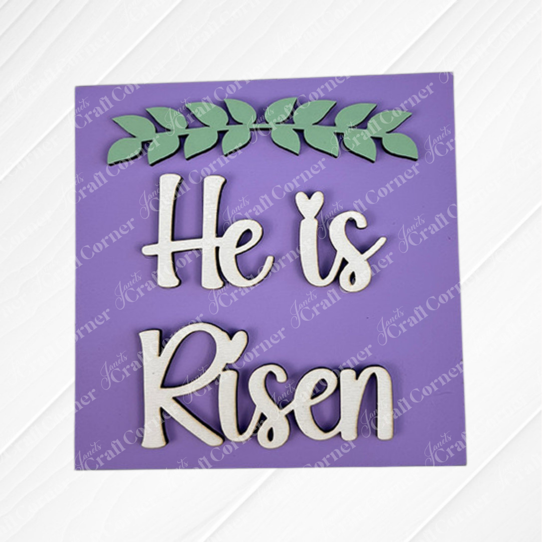 The Religious Easter Squares by Janet's Craft Corner feature a purple sign with white cursive "He is Risen" and a green leafy branch—ideal for tiered trays or pairing with Swappable Squares.