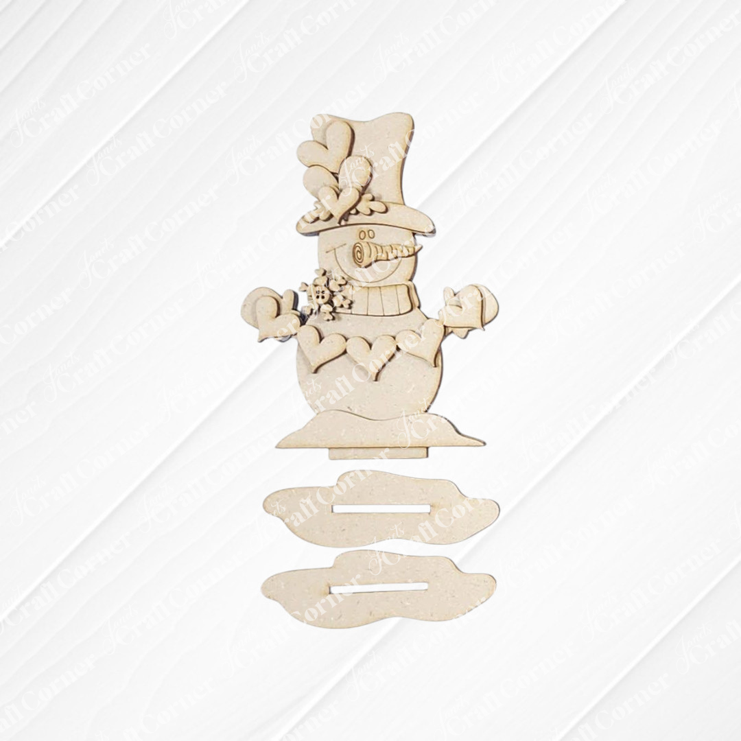 The Hearts Snowman Shelf Sitter DIY craft kit by Janet's Craft Corner includes laser-cut wood pieces to create a festive snowman with a top hat, scarf, and mittens—perfect seasonal home décor or a charming holiday shelf sitter.