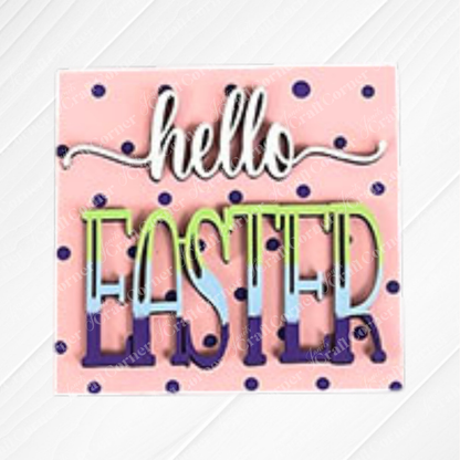 Janet's Craft Corner Hello Easter Squares: Square sign features a pink background with dark blue polka dots, subtle diagonal stripes, and "hello EASTER" in white and pastel rainbow letters—ideal for festive coffee decor or DIY craft displays.
