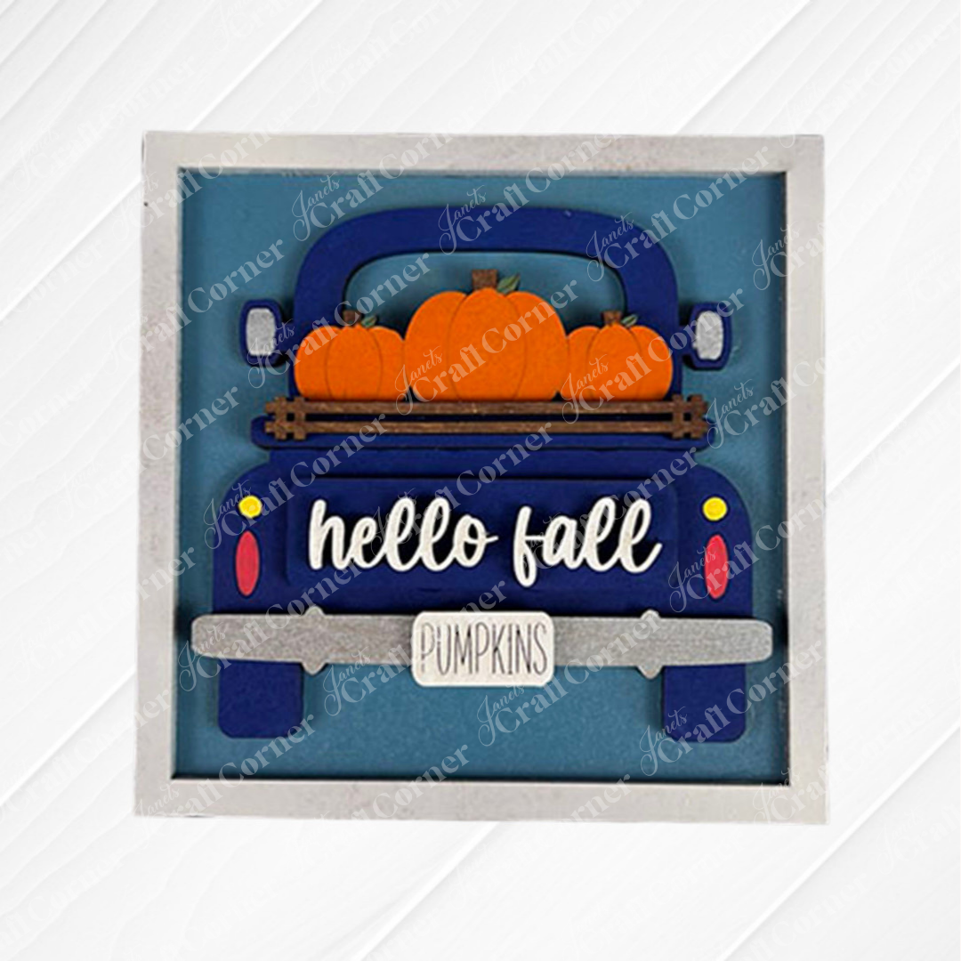 The Hello Fall Squares by Janet's Craft Corner feature a blue vintage truck with orange pumpkins, a "hello fall" sign, and a "PUMPKINS" license plate—perfect for tiered tray decor or festive wood cut-outs on a blue background.