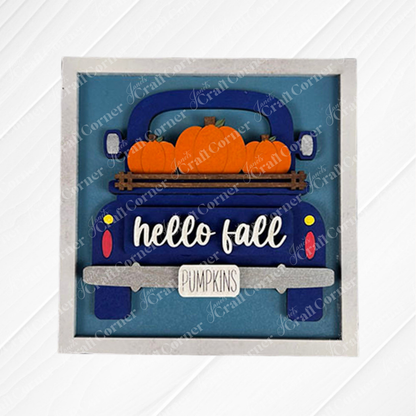 The Hello Fall Squares by Janet's Craft Corner feature a blue vintage truck with orange pumpkins, a "hello fall" sign, and a "PUMPKINS" license plate—perfect for tiered tray decor or festive wood cut-outs on a blue background.