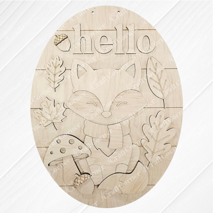 The Hello Fox Oval Door Hanger by Janet's Craft Corner is a DIY craft kit featuring a fox in a scarf, mushrooms, leaves, an acorn, and "hello"—perfect autumn decor for your door. Set of 1.