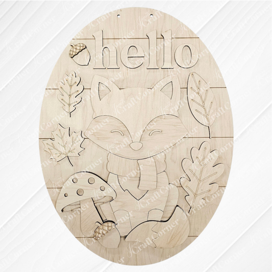 The Hello Fox Oval Door Hanger by Janet's Craft Corner is a DIY craft kit featuring a fox in a scarf, mushrooms, leaves, an acorn, and "hello"—perfect autumn decor for your door. Set of 1.
