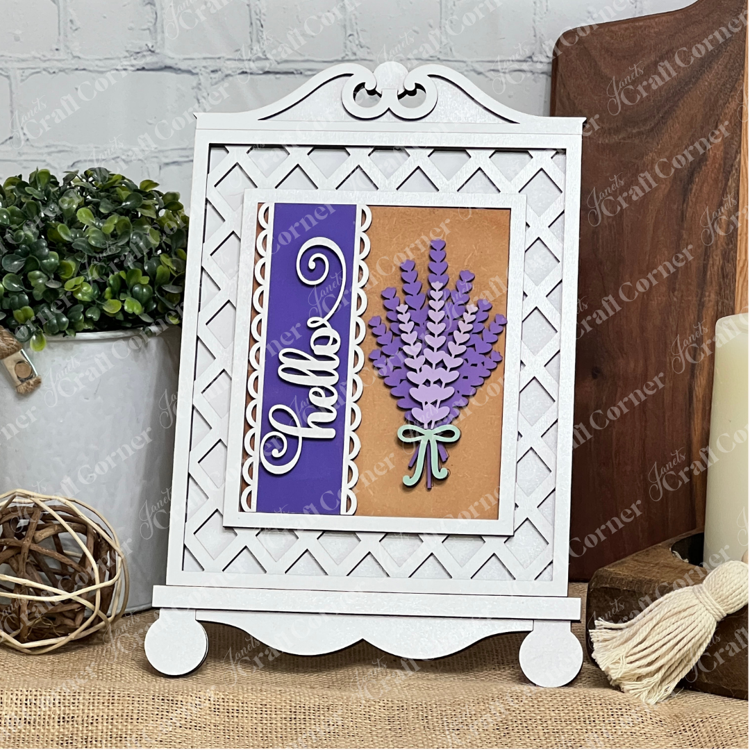 Janet's Craft Corner Cottage Frame for Switchable Farmhouse Signs is a DIY seasonal home decor kit. Display your decorative sign in this white easel-style frame—perfect for adding farmhouse charm to any table alongside plants and candles.
