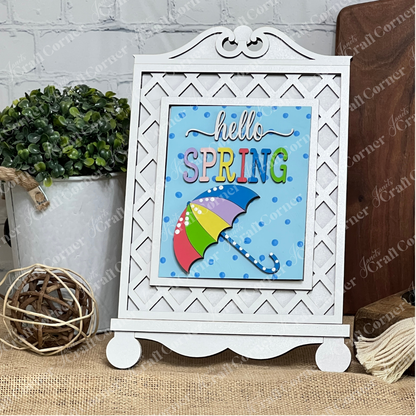 The Cottage Frame for Switchable Farmhouse Signs by Janet's Craft Corner is a DIY seasonal home decor kit. Display the included "hello SPRING" sign with umbrella and polka-dot background for a charming farmhouse look—perfect for updating your space.