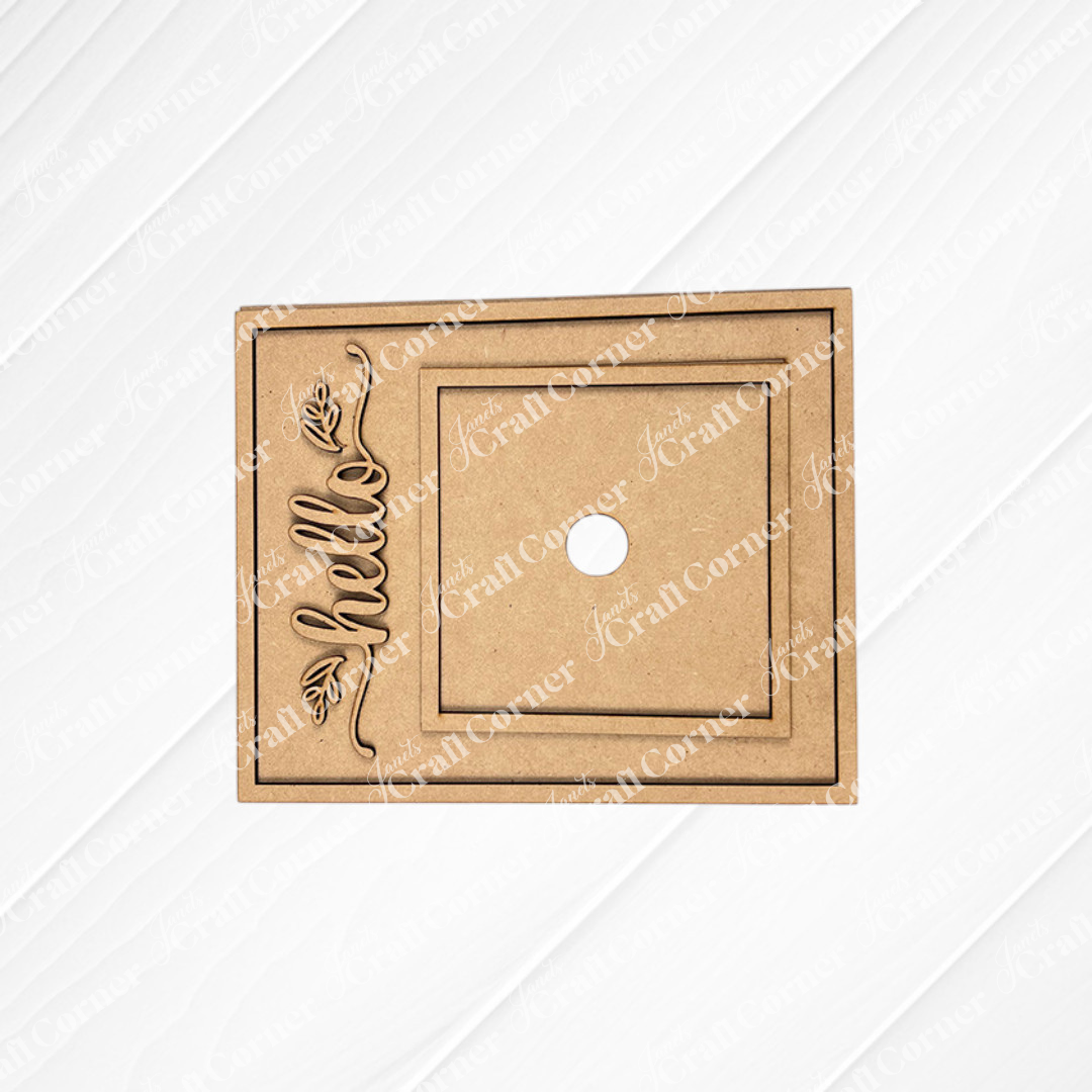 Janet's Craft Corner Hello Swappable Squares Holder DIY Craft Kit: Laser-cut brown MDF rectangle with central hole, square border, and vertically engraved "hello" with leaf—ideal for shelf sitters or seasonal square inserts.