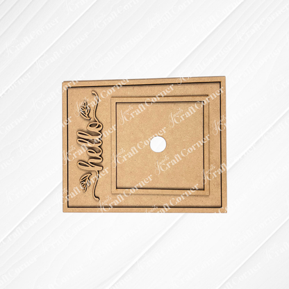 Janet's Craft Corner Hello Swappable Squares Holder DIY Craft Kit: Laser-cut brown MDF rectangle with central hole, square border, and vertically engraved "hello" with leaf—ideal for shelf sitters or seasonal square inserts.