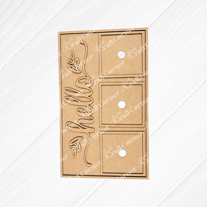 The Hello Swappable Squares Holder - DIY Craft Kit by Janet's Craft Corner is a brown, rectangular holder with three square cutouts, circular finger holes, and a cursive "hello" with a leaf—perfect for displaying seasonal inserts as shelf sitters.