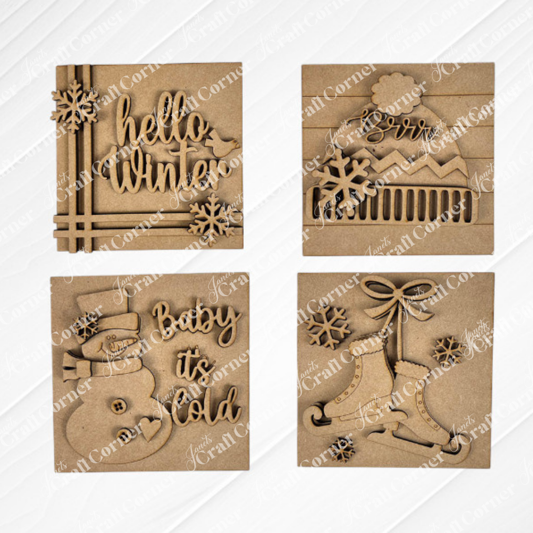 Janet's Craft Corner Hello Winter Squares: four brown, laser-cut wooden ornaments featuring festive designs—"hello winter," "Brrr" mountain, "Baby it’s Cold" snowman, and bells—perfect seasonal decor or tiered tray signs.