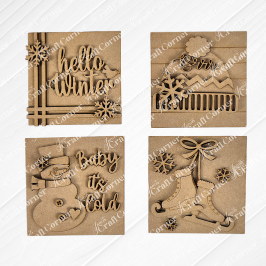 Janet's Craft Corner Hello Winter Squares: four brown, laser-cut wooden ornaments featuring festive designs—"hello winter," "Brrr" mountain, "Baby it’s Cold" snowman, and bells—perfect seasonal decor or tiered tray signs.