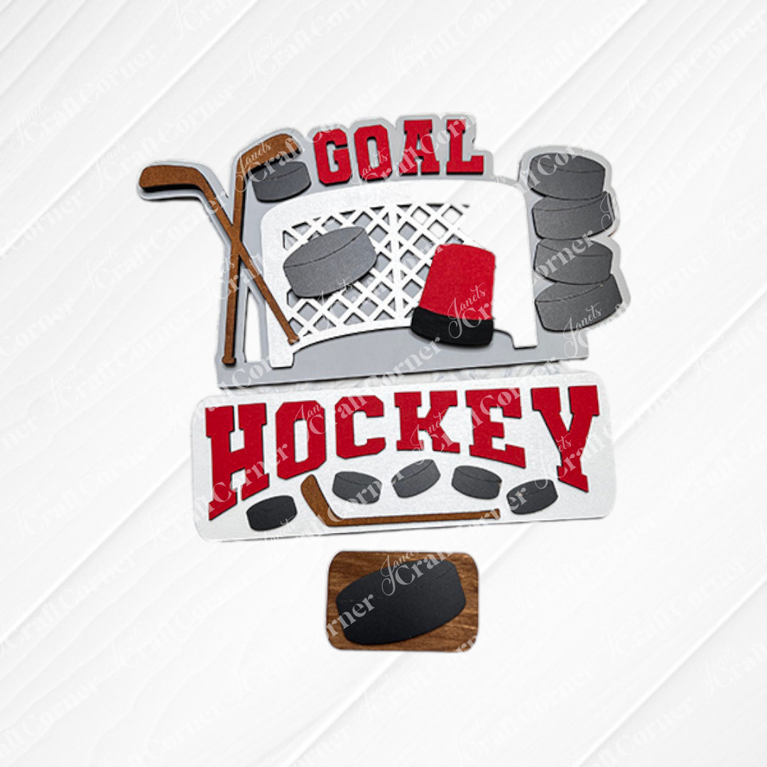 The Hockey Interchangeable Insert - Painted, from Janet's Craft Corner, showcases a decorative hockey-themed design with elements like a goal net, hockey sticks, pucks, and the words "Goal" and "Hockey" in red on a textured white and burlap background. This piece is an ideal addition to your home decor collection.