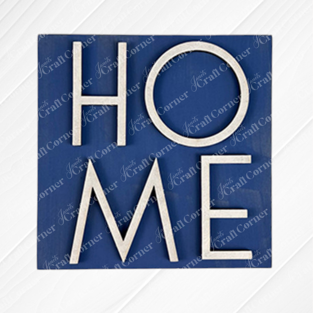 The Home Squares sign by Janet's Craft Corner features "HOME" in bold white letters, with a tilted "O," on a blue square. Ideal for tiered trays or your Swappable Squares collection, it has a subtle watermark background pattern.