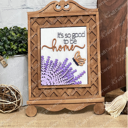 The Cottage Frame for Switchable Farmhouse Signs by Janet's Craft Corner is a DIY seasonal home decor craft kit featuring "It's so good to be home" with lavender flowers and butterfly accents, perfect for rustic displays.