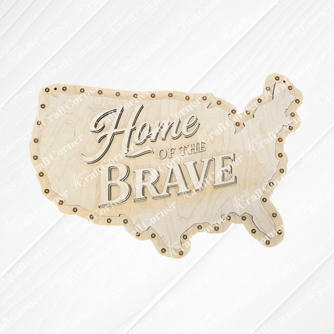 The "Home of the Brave Door/Wall Hanger" by Janet's Craft Corner is an unfinished wooden sign shaped like the US with engraved text and studded borders—ideal for farmhouse wall art or DIY home decor.