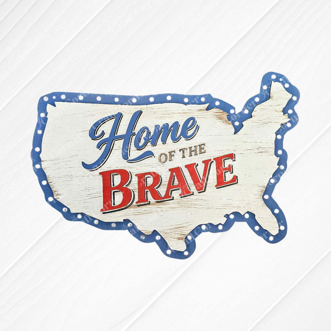 Janet's Craft Corner "Home of the Brave" Door/Wall Hanger features a USA-shaped sign with a blue polka-dotted border and rustic white background—perfect farmhouse wall art or DIY kit for adding patriotic flair.