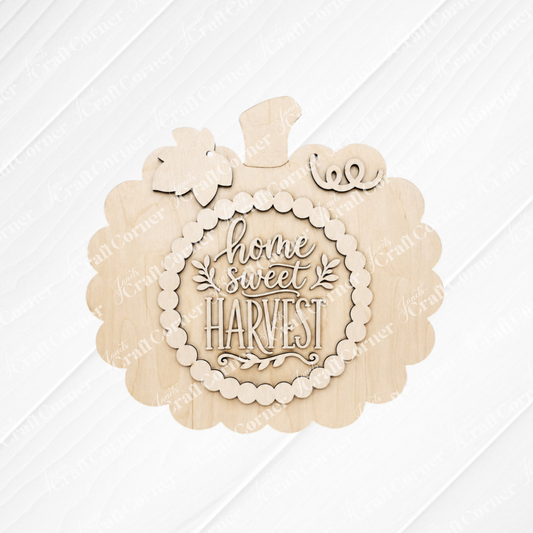 Add a cozy seasonal touch to your space with the Home Sweet Harvest Pumpkin Wall Hanger DIY Craft Kit from Janet’s Craft Corner. This charming set includes a wooden, pumpkin-shaped sign featuring engraved “home sweet HARVEST” text at the center, decorative leaves, plus small pumpkin and vine accents on top. With its light wood paneled background, this kit is perfect for creating your own inviting fall home decor.