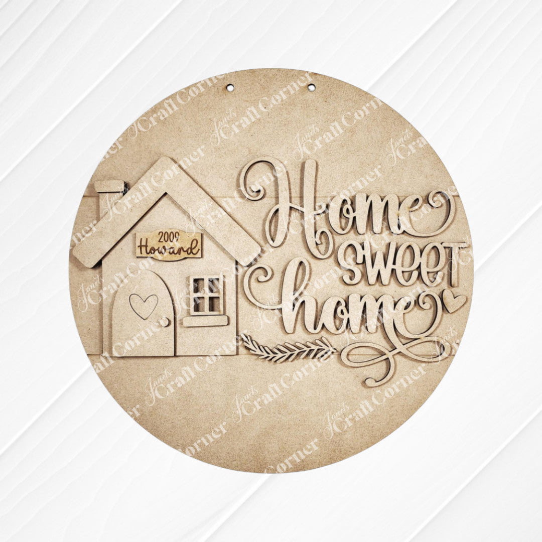 The "Home Sweet Home Door Round" by Janet's Craft Corner is a round wooden plaque for home décor. It features the text "Home Sweet Home," a house design with a heart, and "Welcome" on a white panel, making it ideal as a DIY craft kit to personalize any living space.