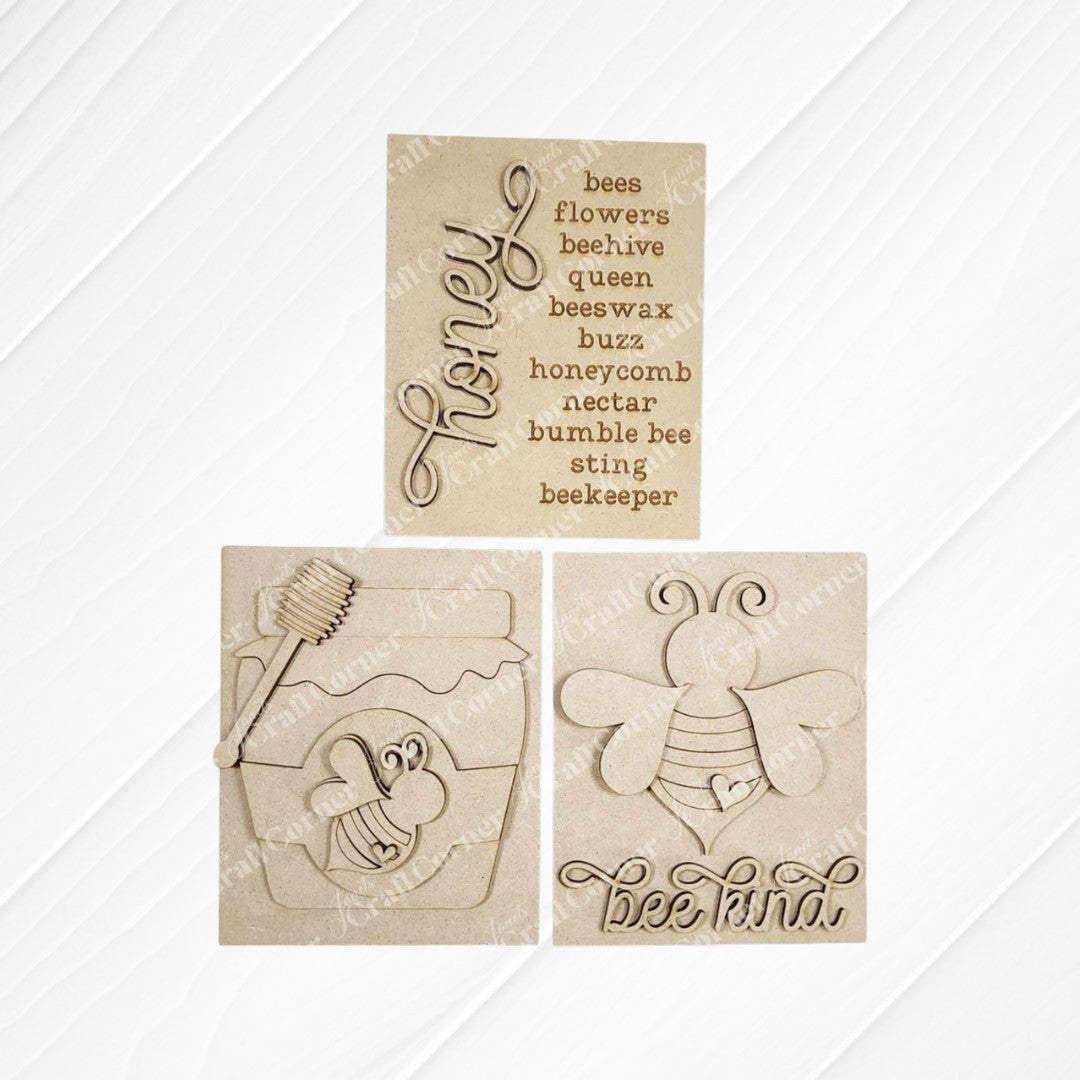 The Honey Bee Farmhouse Sign by Janet's Craft Corner is a delightful DIY home decor craft kit, featuring three options with bee and honey themes: one saying "bee kind" with a buzzing bee, another with bee-related words, and a honey jar design in script.