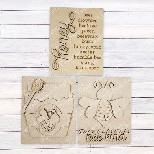 The Honey Bee Farmhouse Sign by Janet's Craft Corner is a delightful DIY home decor craft kit, featuring three options with bee and honey themes: one saying "bee kind" with a buzzing bee, another with bee-related words, and a honey jar design in script.